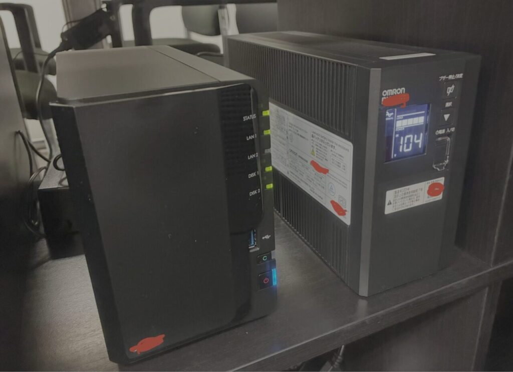ミライクラフト税理士事務所内で実際に稼働している、外部アクセスを遮断したバックアップ用NAS(左)と、停電やコンセント抜けからデータを守るオムロン製無停電電源装置・UPS(右)|ミライクラフト税理士事務所